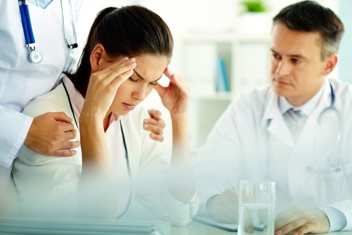 female patient headache with doctor copy